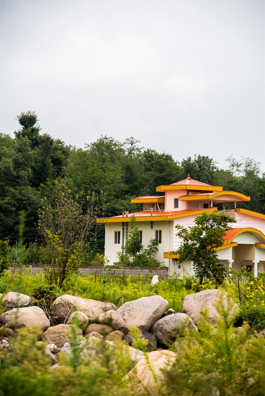 A villa in a green garden with stone landscaping